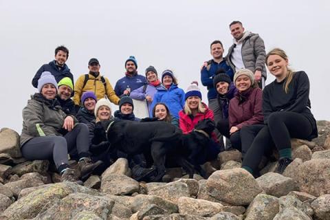 Group of Muckle staff sitting on a hill in climbing gear