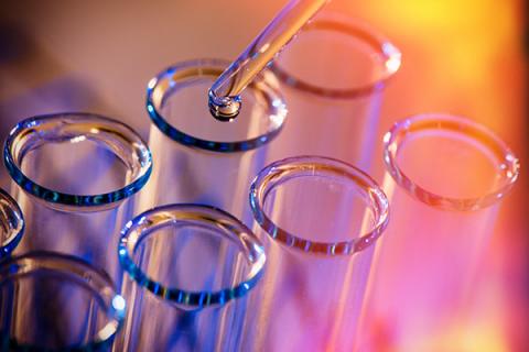 Multi-coloured close-up of test tubes with a pipette