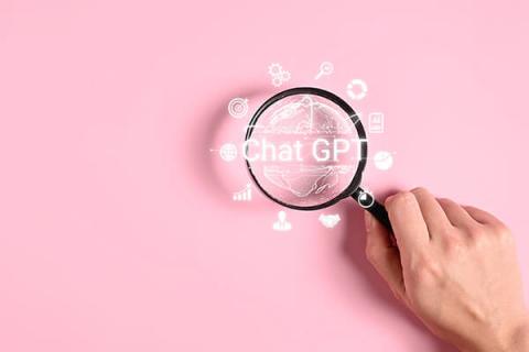 Magnifying glass looking at Chat GPT wording and symbols on a pink background