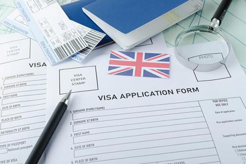 a UK Visa application form and pen