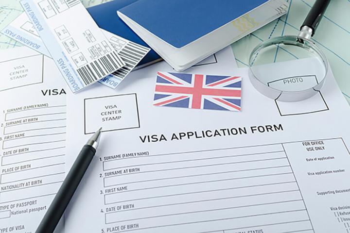 a UK Visa application form and pen
