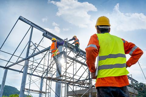 construction worker looking up at a building frame