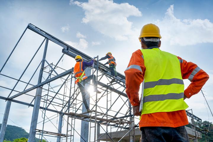 construction worker looking up at a building frame