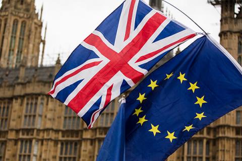 Houses of Parliament with Union Jack and EU flags in front