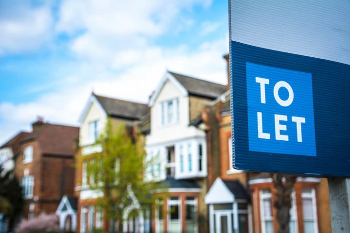 A row of houses with a To Let sign in the foreground