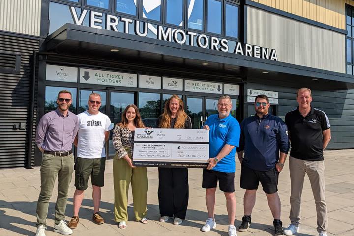 7 people holding a cheque