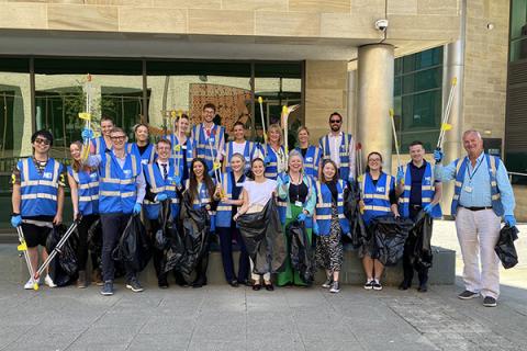 A group of Muckle volunteers in blue hi-vis jackets smiling at the camera