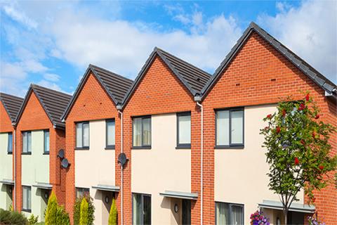 Row of new build houses against a blue cloudy sky