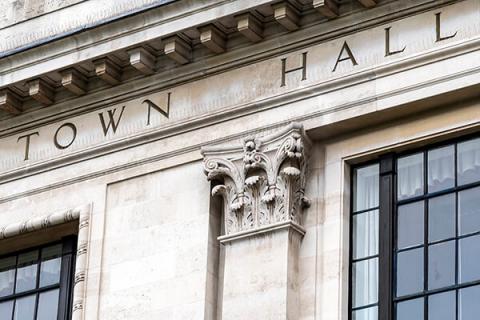 Picture of a town hall with town hall etched in stone on the front of the building