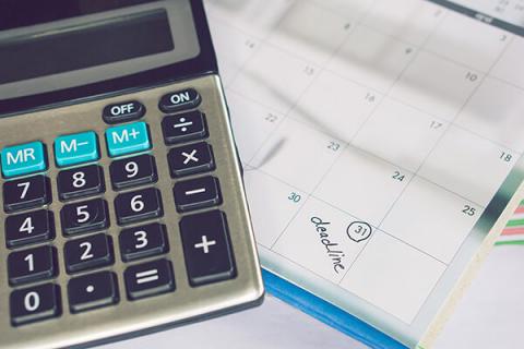 A calculator on top of a diary with a date circled