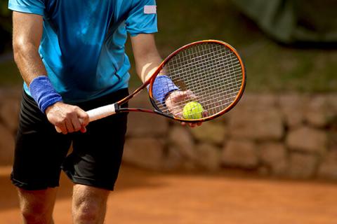 man serving tennis ball