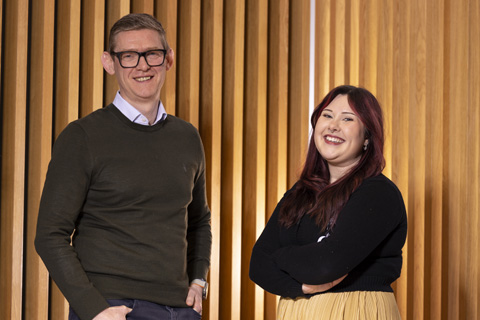 Anthony evans and Melissa Henderson in front of wooden slats