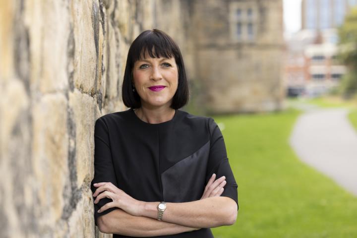 Woman with short bob haircut leaning against a wall