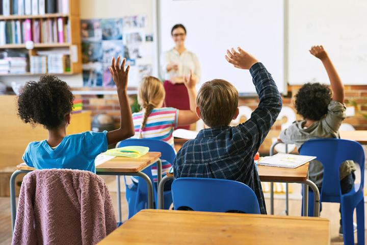 Children raising their hands in a classroom