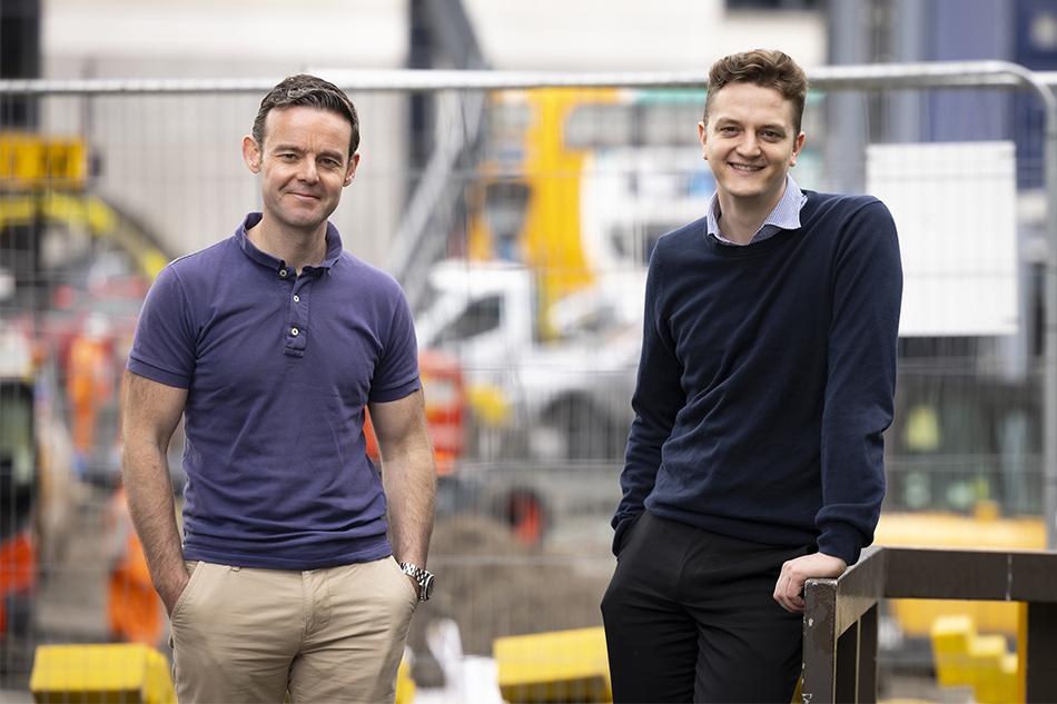 Adam Aston and Kieran Woonton in front of some building works