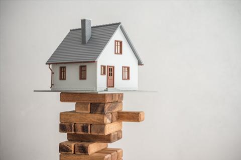 House balancing on Jenga tower