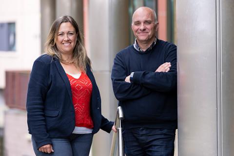 Alison Walton and Jason Wainwright standing side by side outside, jason is leaning against a post with his arms crossed.