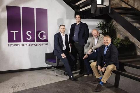 Four men in front of a purple logo that says TSG