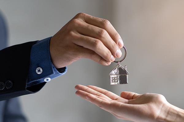 Landlord hands over house keys to a renter to access their new home