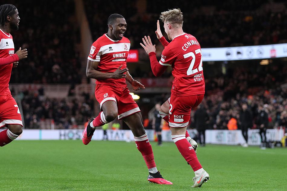two middlesbrough football players celebrating on the pitch