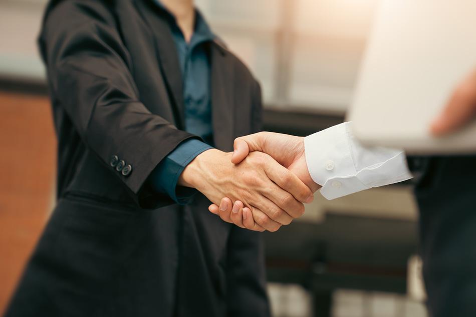 Two people shaking hands as part of a business agreement