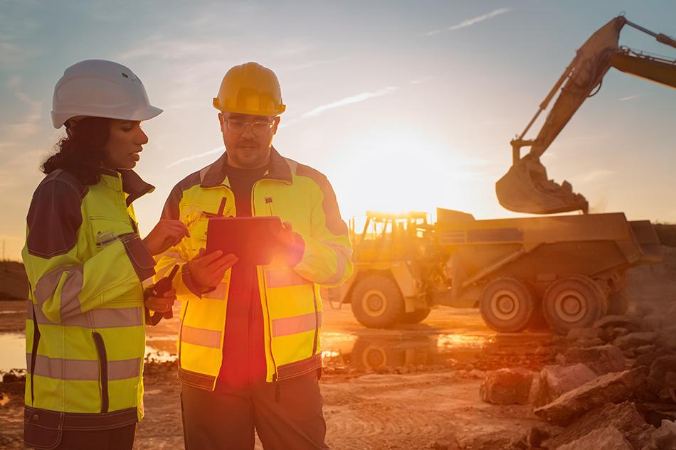 Two construction looking at a tablet workers discussing a project