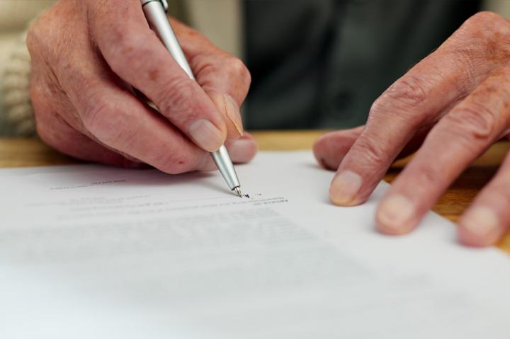 Man writing will in legal office