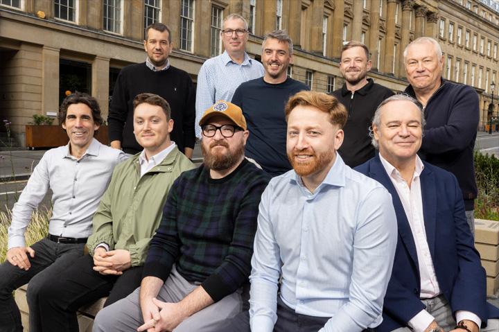 ten men sitting outside a building