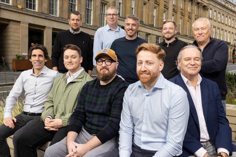 ten men sitting outside a building