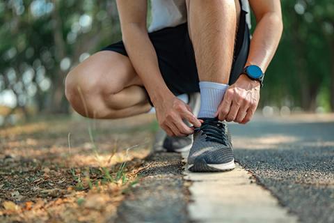 A cross country runner checking his progress through a smart watch
