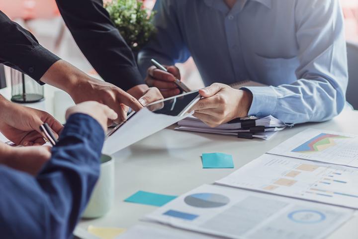 Image of a business meeting taking place, with participants sharing data