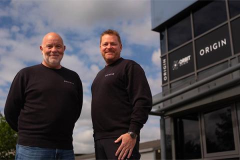 Phil Surtees and John Marsden dressed in black standing in front of the Origin Tech building