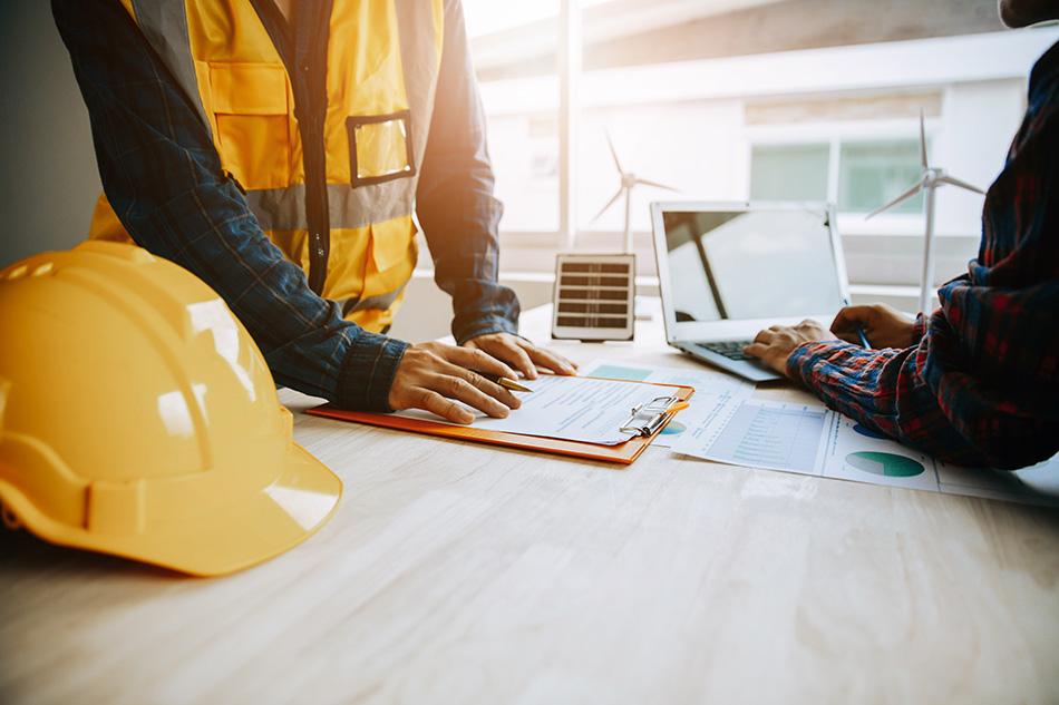 Two construction workers discussing a contract in an office setting