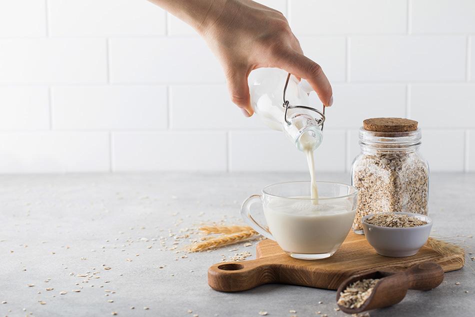 Image of someone pouring oat milk into a glass