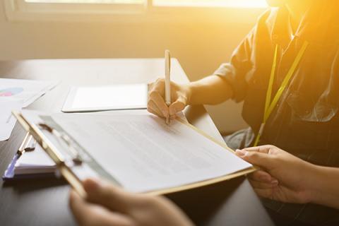 Person signing a rental contract in an office