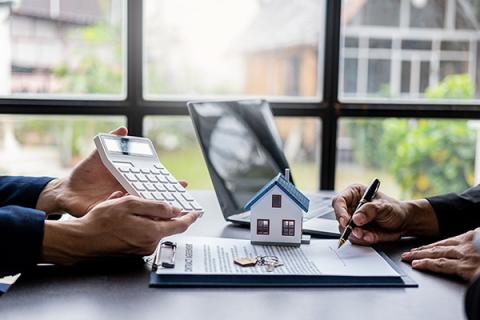 Image of person signing a lease in an office setting