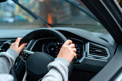 Learner driver with hands on the steering wheel ready to drive