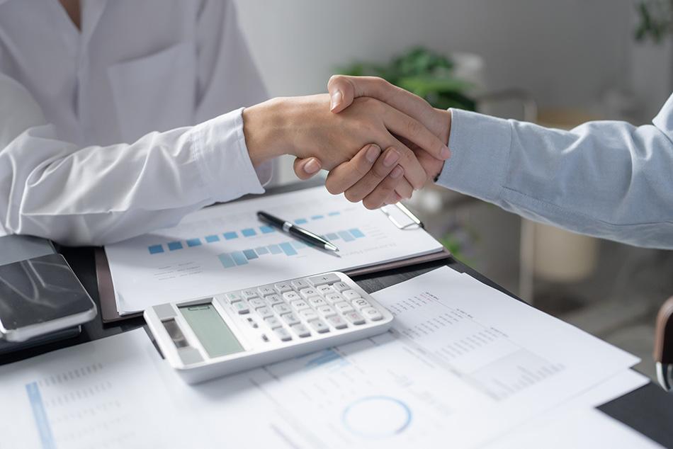 two professionals shaking hands following a business deal
