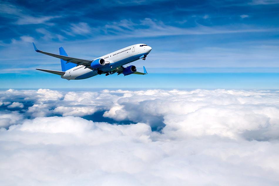 An image of a plane above the clouds in the sky.