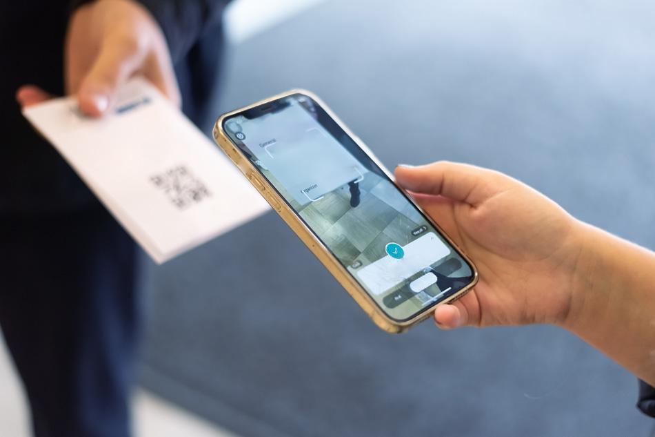 An entry of a customer scanning a QR code on their phone to enter an event.