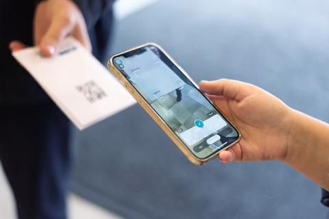 An image of an events manager scanning someone's ticket on their phone