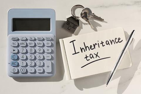 a picture of a calculator, bunch of keys, and a post it note saying inheritance tax