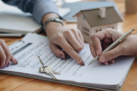 A renter signing a lease in an office setting.