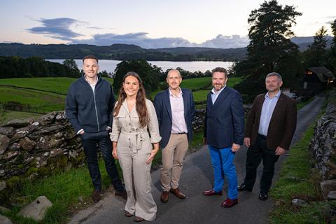 Group of people posing for photo in front of Cumbrian lake